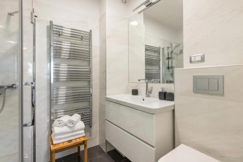 a white bathroom with a sink and a shower at Relax & Recharge SEA VIEW Apartment in Split