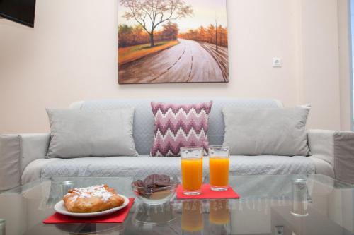 a living room with a couch with two glasses of orange juice at Luna Rossa Santorini in Imerovigli