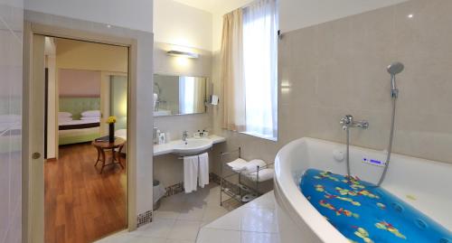 a bathroom with a bath tub and a sink at Hotel Master in Brescia