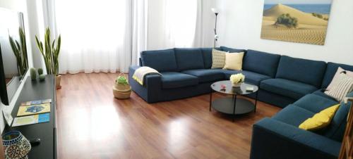 ein Wohnzimmer mit einem blauen Sofa und einem Tisch in der Unterkunft Canarifornia in Telde