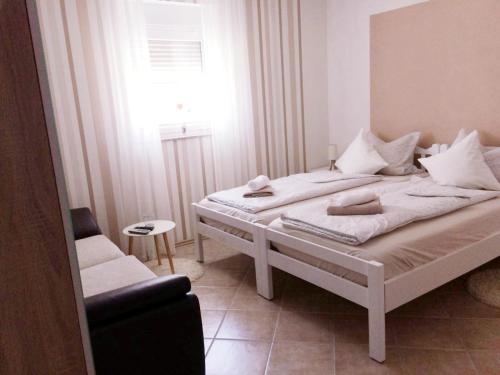 a bedroom with two beds and a chair and a window at Nina in Zadar