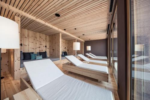 a row of beds in a room with wooden walls at Hotel Lamm in Castelrotto