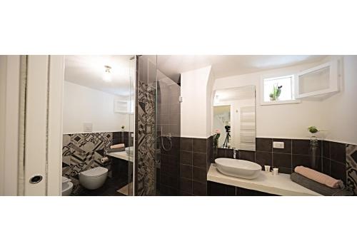 uma casa de banho com 2 lavatórios e um chuveiro em La Rosa del Corso em Fasano