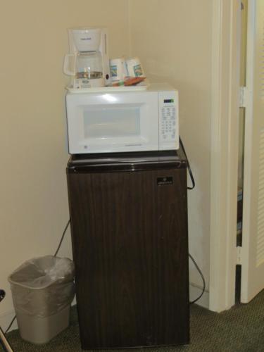 a microwave sitting on top of a refrigerator at Travelodge by Wyndham Palm Springs in Palm Springs