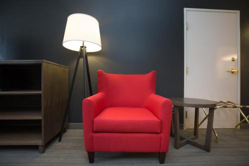 a red chair sitting next to a floor lamp at Country Inn & Suites by Radisson, Boone, NC in Boone