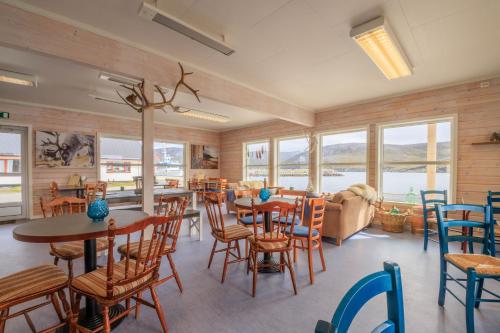 een kamer met tafels en stoelen en een bank bij Seaside cabin Skarsvåg in Skarsvåg