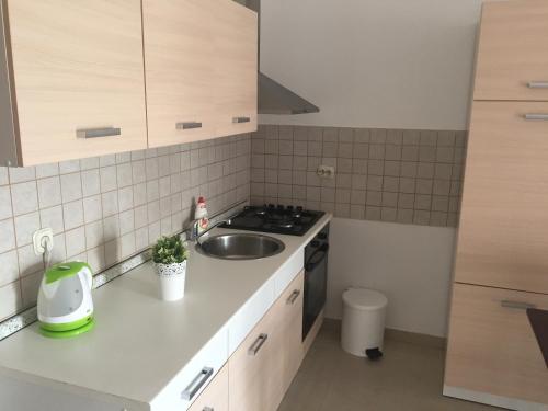 a small kitchen with a sink and a stove at Aurora in Pag