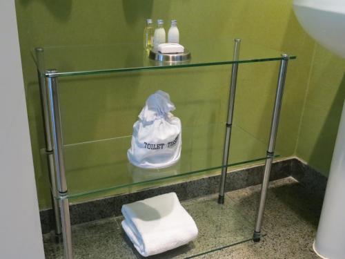 a glass shelf in a bathroom with towels on it at 7 Springs Inn & Suites in Palm Springs