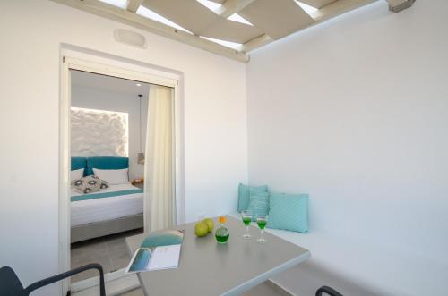 Cette chambre blanche dispose d'une table et d'un lit. dans l'établissement 3 Wishes, à Naxos Chora