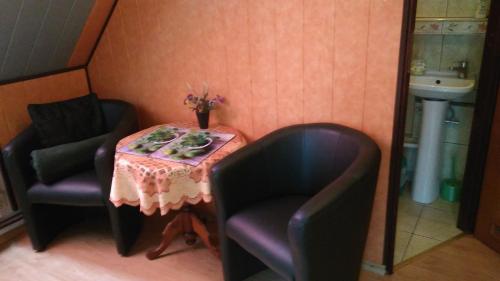 a small table with two chairs and a table with flowers at Pokoje Gościnne Na Górach in Kazimierz Dolny