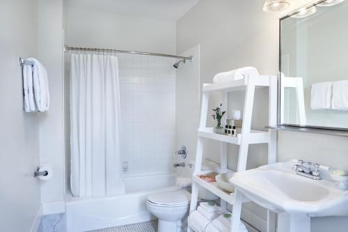 een witte badkamer met een toilet en een wastafel bij Inn at Carnall Hall in Fayetteville