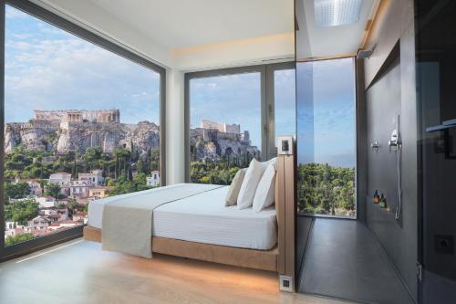 a bedroom with a bed with a view of the acropolis at Athens Avaton Suites in Athens