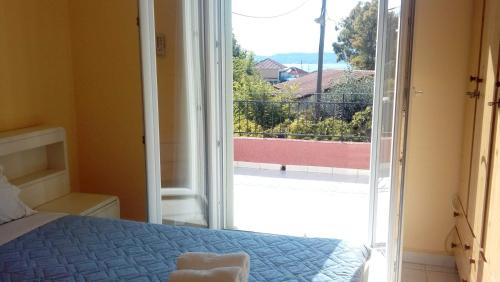 a bedroom with a bed and a large glass door at Yellow house in Lassi
