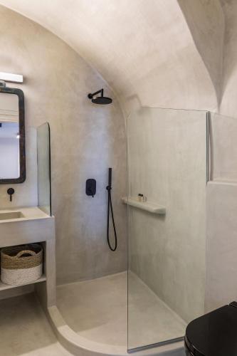 a bathroom with a shower with a glass door at 3 Caves by Caldera Houses in Oia