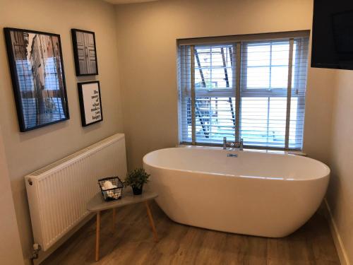 a bath tub in a bathroom with a window at number 26 in Conwy