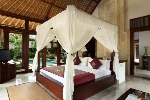 um quarto com uma cama de dossel em The Ubud Village Resort & Spa em Ubud