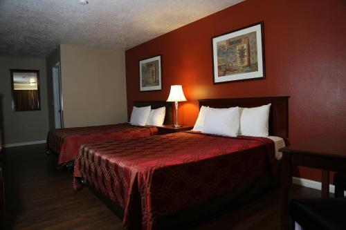 - une chambre d'hôtel avec 2 lits aux murs rouges dans l'établissement Americas Best Value Inn Kelso, à Kelso