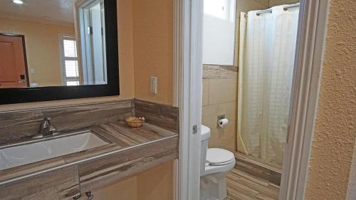 a bathroom with a toilet and a sink and a mirror at Rosa Bell Motel - Los Angeles in Los Angeles