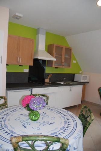 une cuisine avec une table avec un vase de fleurs dessus dans l'établissement E-Harz Ar Menez, à Mont-Dol