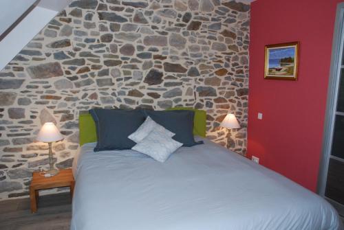 a bedroom with a large bed with a stone wall at E-Harz Ar Menez in Mont-Dol