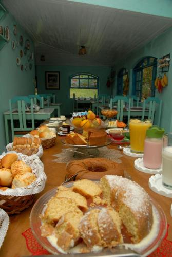 a table topped with plates of bread and pastries at Pousada Mirante do Penedo in Penedo