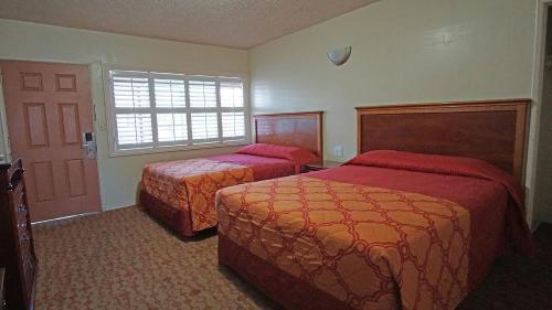 a hotel room with two beds and a door at Rosa Bell Motel - Los Angeles in Los Angeles