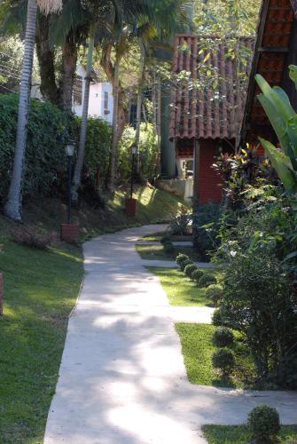 a walkway in front of a house with palm trees at Pousada Mirante do Penedo in Penedo