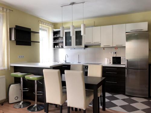 ペーチにあるLuxory Homeの白いキャビネット、テーブルと椅子付きのキッチンが備わります。