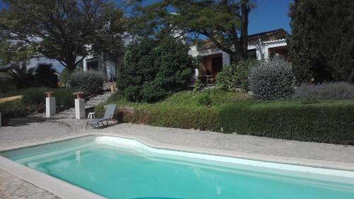 a swimming pool in front of a house at La Escuela del Campo in Setenil