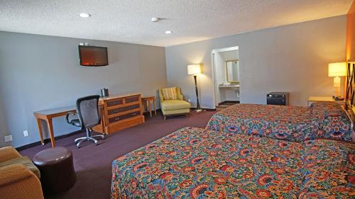 a hotel room with two beds and a desk at Los Angeles Inn & Suites - LAX in Los Angeles