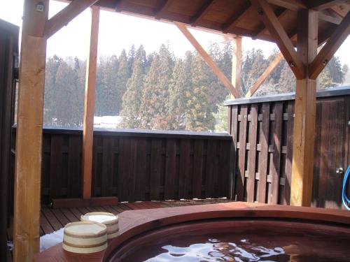 a hot tub on the deck of a wooden cabin at Hakuba Hotel Hana-no-Sato in Hakuba