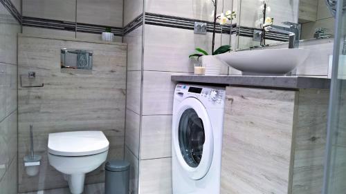a bathroom with a washing machine and a sink at ATapartments - Cztery Oceany I in Gdańsk