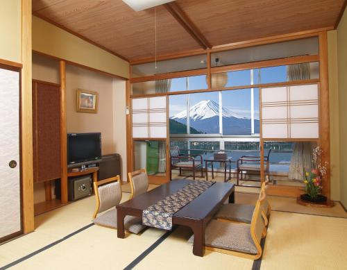 a living room with a view of a mountain at Hotel New Century in Fujikawaguchiko