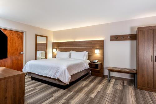 a hotel room with a bed and a mirror at Holiday Inn Express Chapel Hill by IHG in Chapel Hill