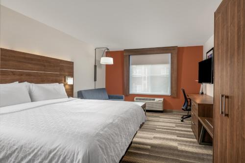 チャペルヒルにあるHoliday Inn Express Chapel Hill, an IHG Hotelのベッドとテレビが備わるホテルルームです。