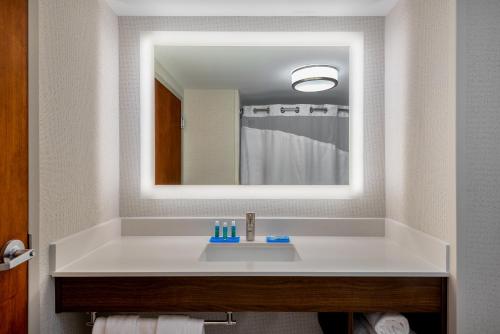 a bathroom with a white sink and a mirror at Holiday Inn Express Chapel Hill by IHG in Chapel Hill