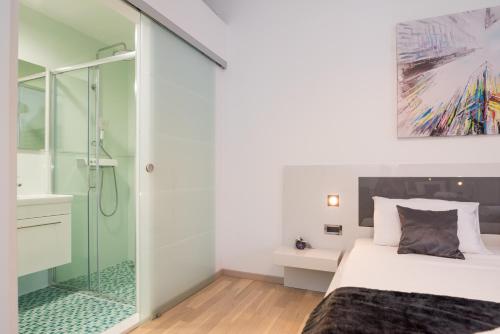 a bedroom with a glass shower and a bed at Luxury apartment Shelena in Mravince