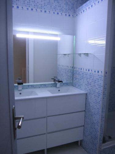 une salle de bain blanche avec un lavabo et un miroir dans l'établissement APPARTEMENT DUPLEX 71 m2 - 4 personnes, à La Grande Motte