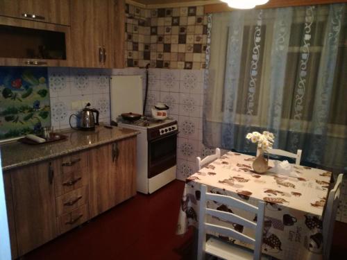 a kitchen with a table and a stove and a table and chairs at Lakeside Green Balcony Home in Tskaltubo