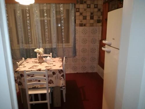 a small kitchen with a table and a refrigerator at Lakeside Green Balcony Home in Tskaltubo
