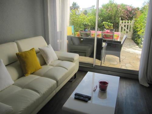 un salon avec un canapé blanc et une table dans l'établissement APPARTEMENT DUPLEX 71 m2 - 4 personnes, à La Grande Motte