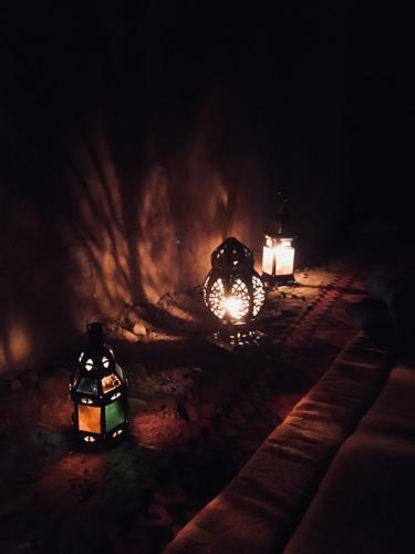 two lit up lanterns on the ground at night at Auberge L'Oasis Mhamid in Mhamid
