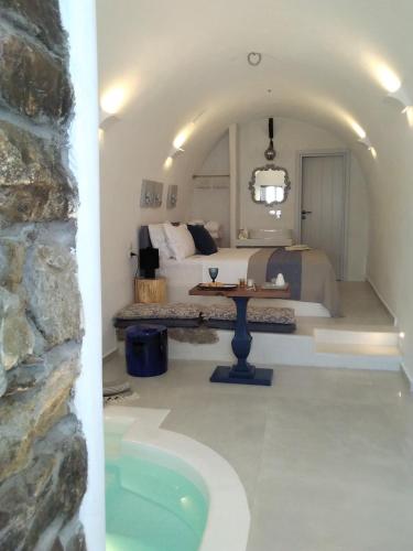 a bedroom with a bed and a tub in a room at Esperia Luxury Suites in Astypalaia
