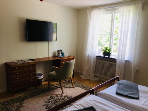 a bedroom with a desk with a computer and a window at Stavsjö Herrgårdsflygel in Stavsjo