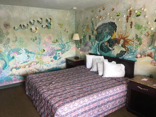 um quarto com uma cama com um quadro na parede em Deluxe Inn em Galloway