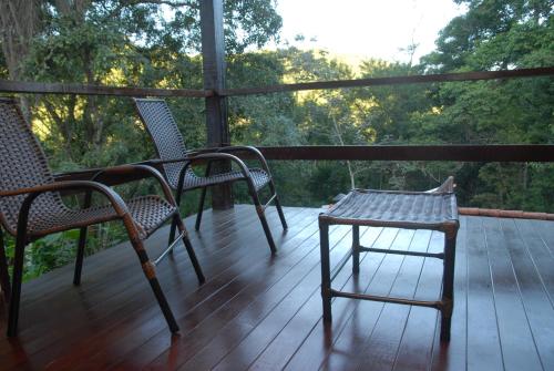 two chairs and a table on a porch at Pousada Mirante do Penedo in Penedo
