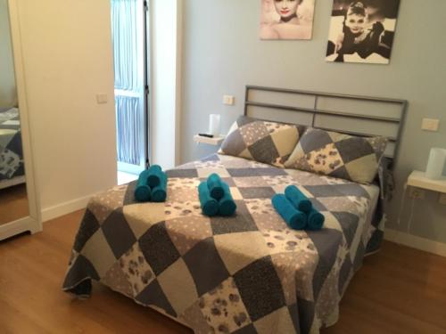 a bedroom with a bed with blue slippers on it at Seaside Apartment Gran Canaria in La Garita