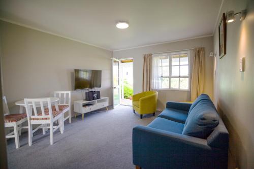 a living room with a blue couch and a table at Phoenix Thermal Resort - Taupo in Taupo