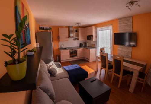 sala de estar con sofá, mesa y cocina en Powderia Family & Freelance Apartment in the center of Ski Amadé, en Altenmarkt im Pongau