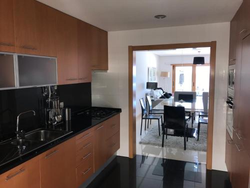 a kitchen with a sink and a dining room at Apartamento con vistas al Mar in Sesimbra
